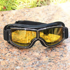 Motorcycle goggles with yellow lenses on a stone surface