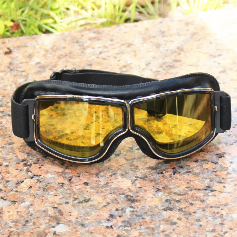 Motorcycle goggles with yellow lenses on a stone surface