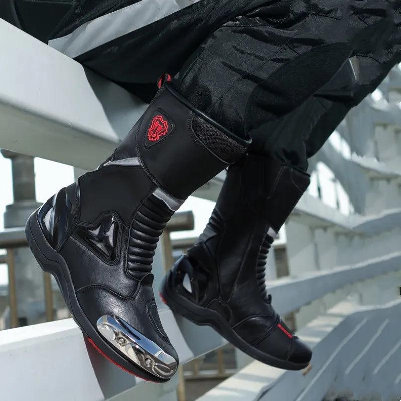 Black motorcycle boots with red accents on a person sitting on a white railing.