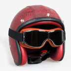 Red leather helmet with goggles on a white background
