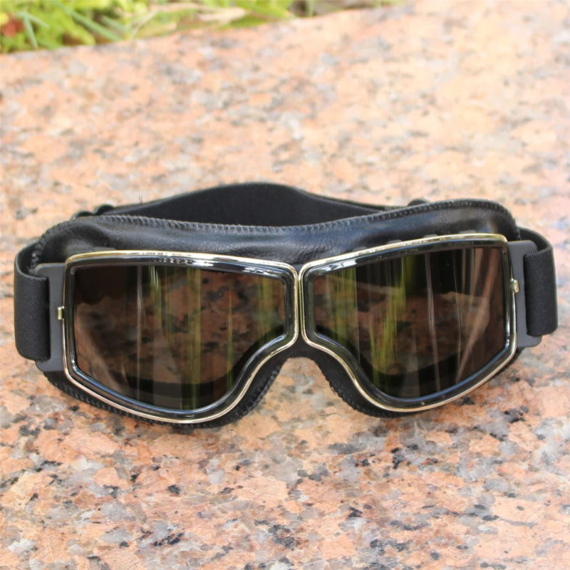 Black goggles with reflective lenses on a textured surface