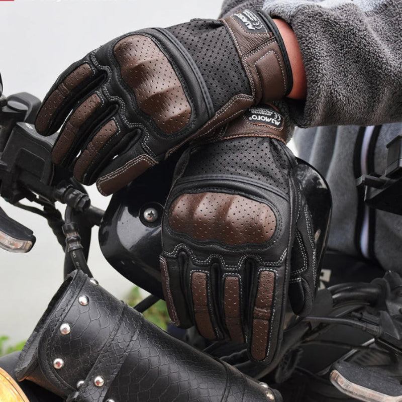 Person wearing black and brown motorcycle gloves on a motorcycle 
