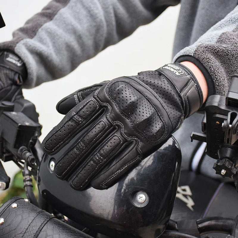 Person wearing black cycling protective gloves on a motorcycle.
