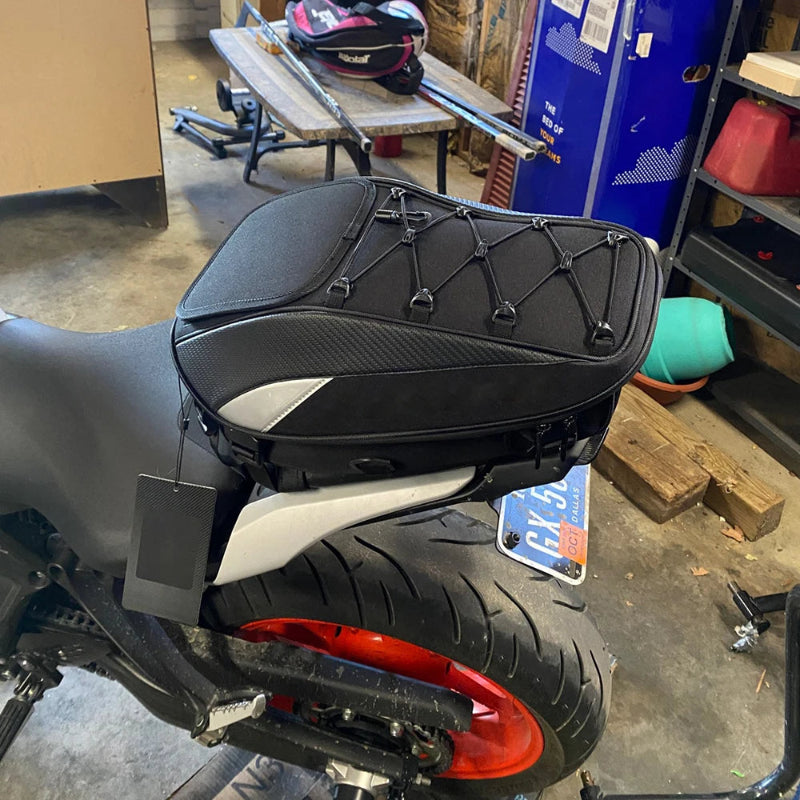 Motorcycle with a black saddlebag in a workshop setting